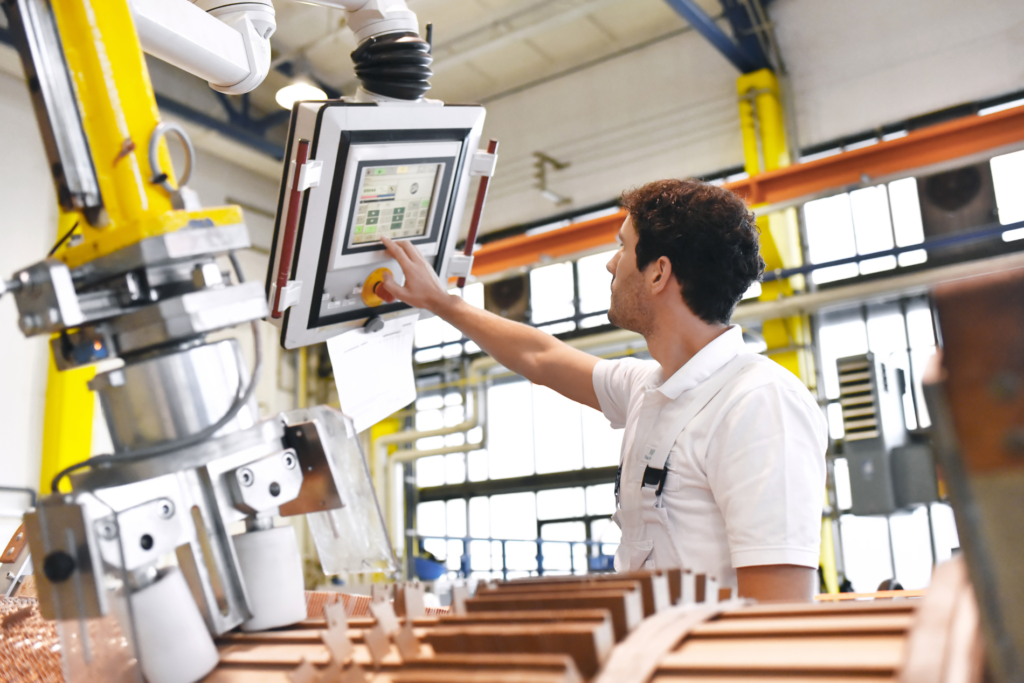 a worker uses a digital device on a manufacture production environment